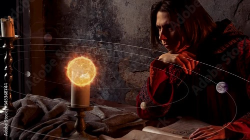 history of scientific knowledge, the concept. A young man in the image of the scientist of the middle ages and Renaissance Nicholas Copernicus, working on the heliocentric system of the world photo