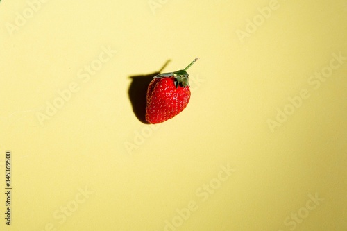 red strawberry on a sheet of yellow canton