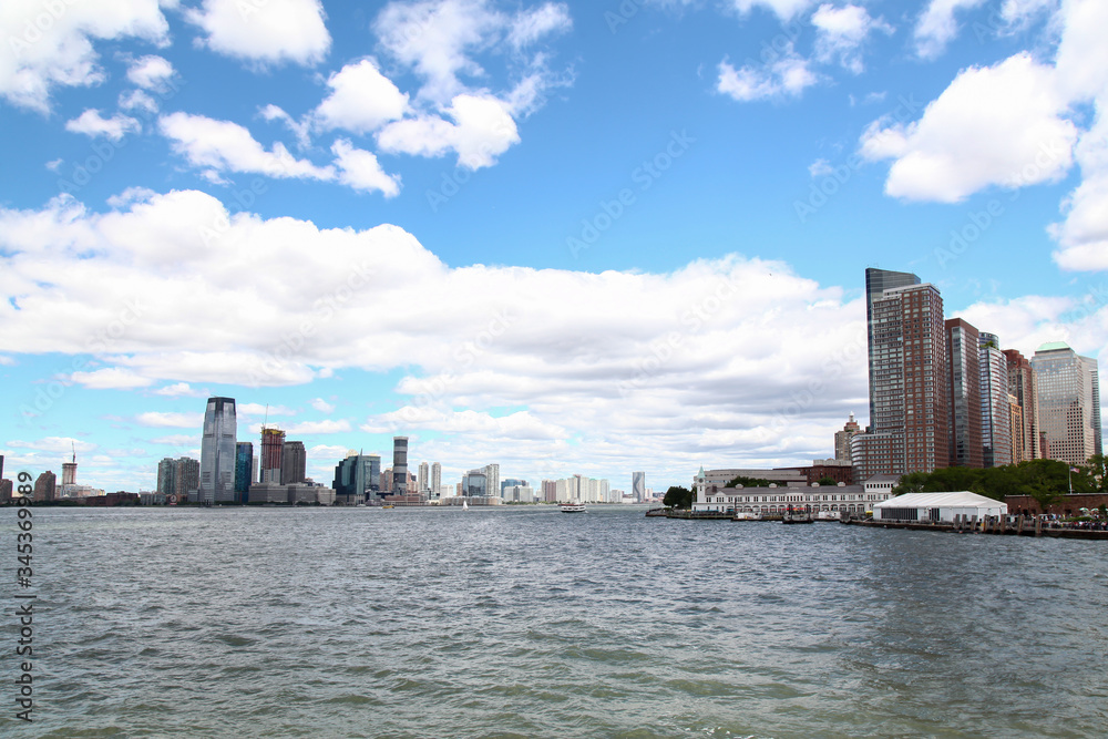 New York,USA-June 15 ,2018 :Look on the sailboat is cruising in New York harbor buildings of Manhattan island in the background. New York,USA-June 15 ,2018 :Look on the sailboat is cruising in New York harbor buildings of Manhattan island in the background.