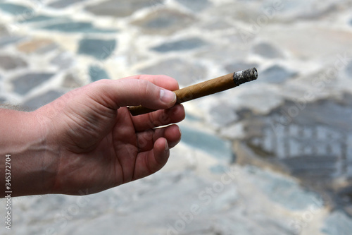 man's hand with a cigar on the road
