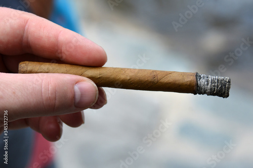 man's hand with a half-burn cigar