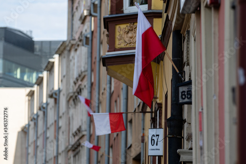 Polish state flags hung on the walls of the houses of the city