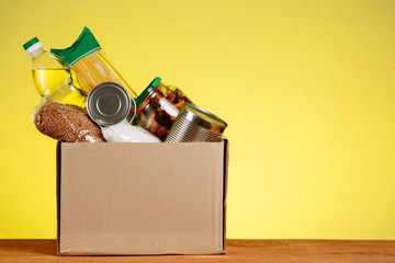 A box of food on the table. Humanitarian assistance to people in difficult situations due to the COVID 19 coronavirus pandemic. Volunteer package for the elderly.