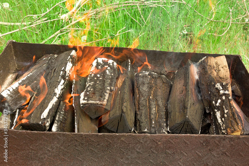 Burning firewood in the grill for cooking. Close-up. Horizontal.