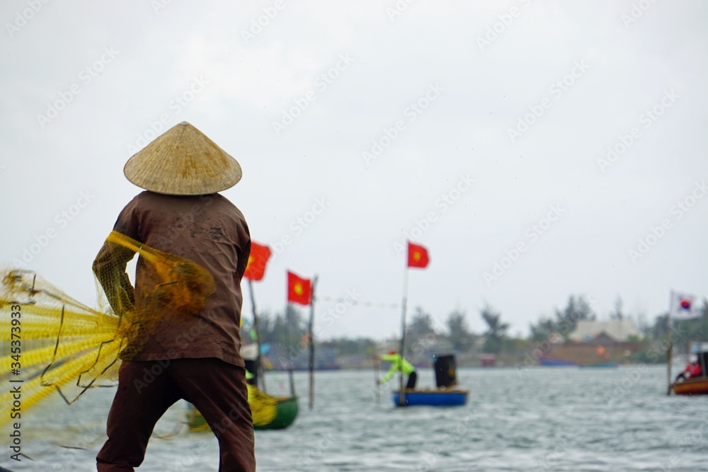 vietnamese fisherman fishing with net