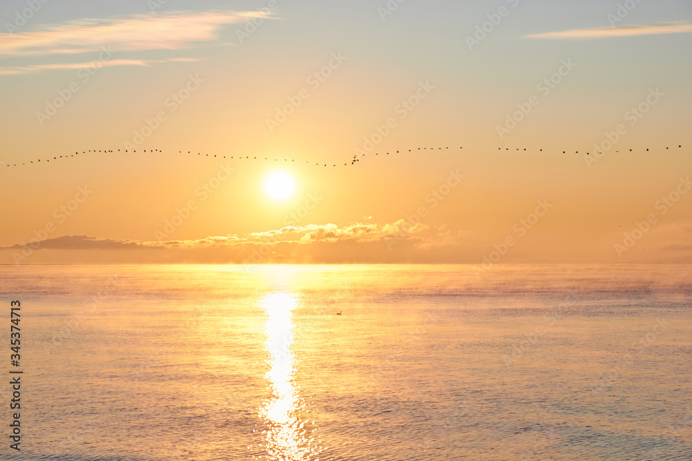 Dawn over the sea with clouds and fog