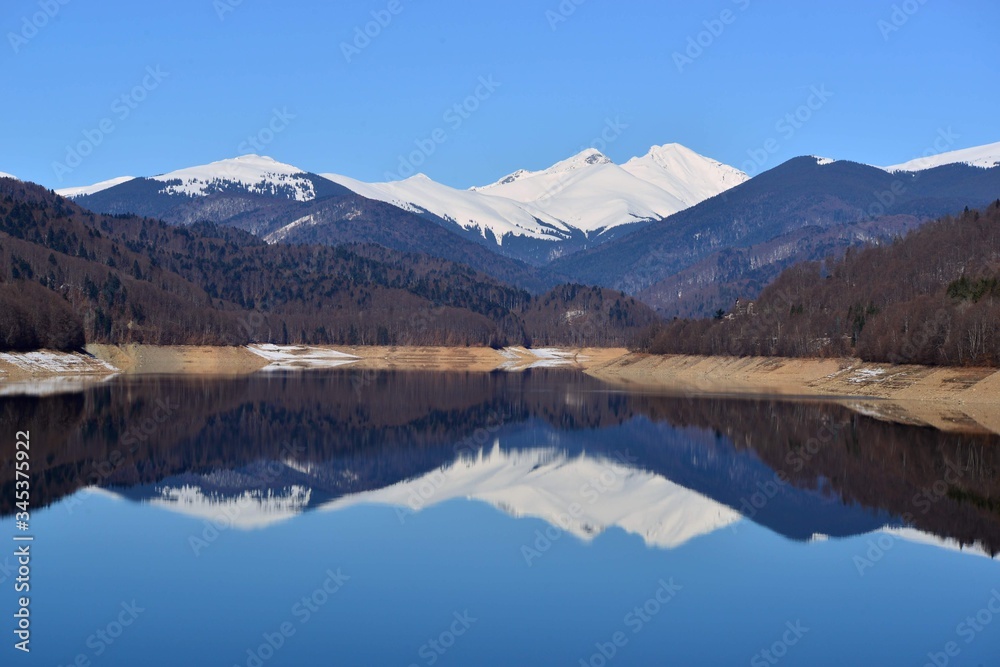 snowy mountains reflecting in the lake with blue sky snowy mountains reflecting in the lake with blue sky