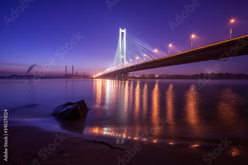 The South bridge at night, Kyiv, Ukraine. Bridge at sunset across the Dnieper River. Kyiv bridge against the backdrop of a beautiful sunset in Kyiv. 