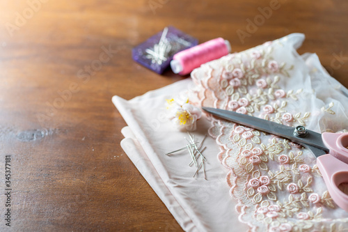 Accessories for home sewing on a pink background. Tailor table. Making textiles or fine fabrics.