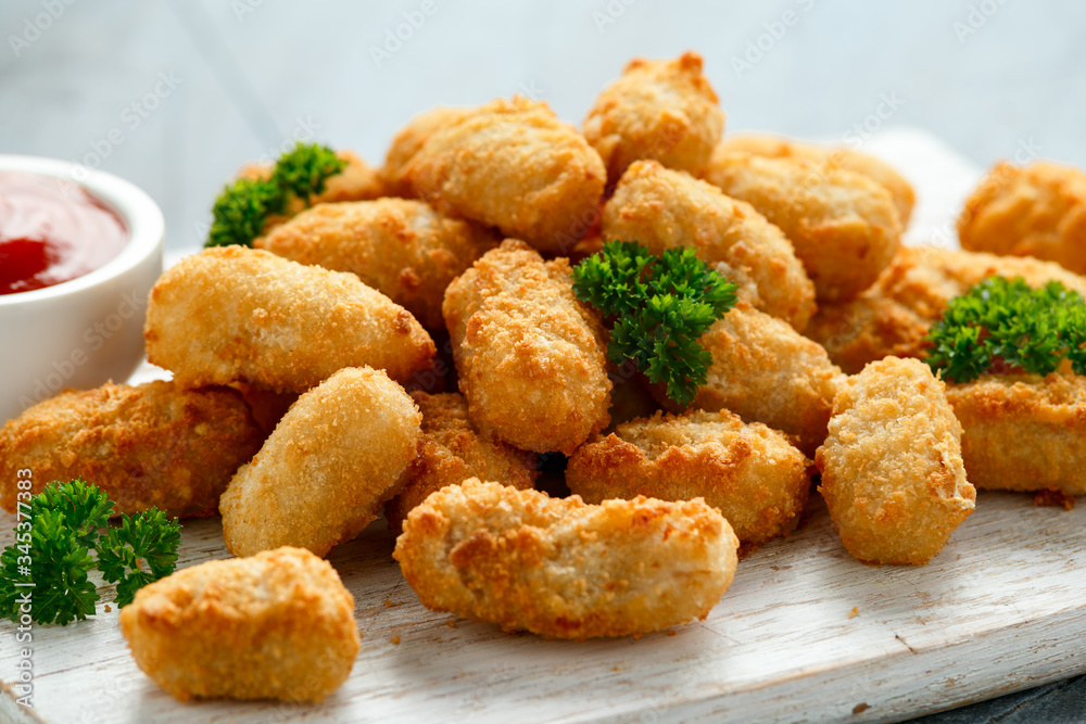 Crispy Battered scampi nuggets with ketchup on white wooden board Crispy Battered scampi nuggets with ketchup on white wooden board