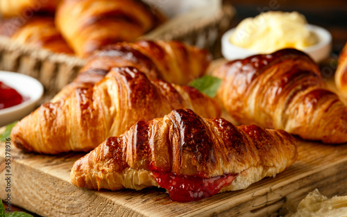 Freshly baked croissants with butter, strawberry jam and tea for breakfast or brunch © grinchh