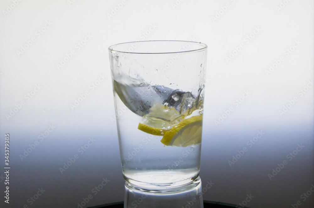 Lemon slice splash effect when falling into a glass with water Lemon slice splash effect when falling into a glass with water