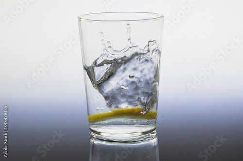 Lemon slice splash effect when falling into a glass with water