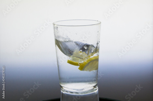 Lemon slice splash effect when falling into a glass with water