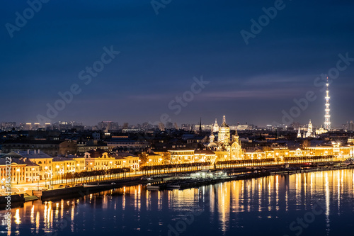 The river reflects the city lights. Twilight city panoramic landscape. View of the Old city over the roofs of houses. Saint Petersburg is a city on the Neva river.
