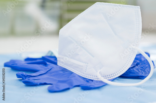 Face mask and blue latex gloves on blue background.Medical tool for personal protection equipment.Medical accesory for infectious control concept.