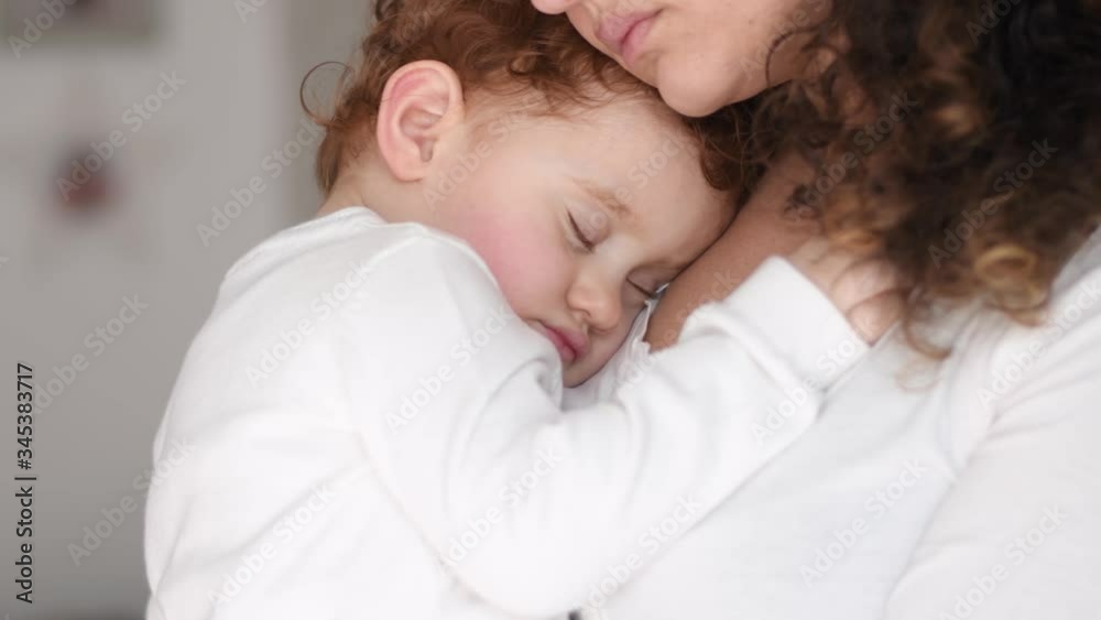 Close up portrait of beautiful young Caucasian mother bringing little girl who sleeps between her in the house and sunlight in the morning. Health, love, relationship concept Close up portrait of beautiful young Caucasian mother bringing little girl who sleeps between her in the house and sunlight in the morning. Health, love, relationship concept