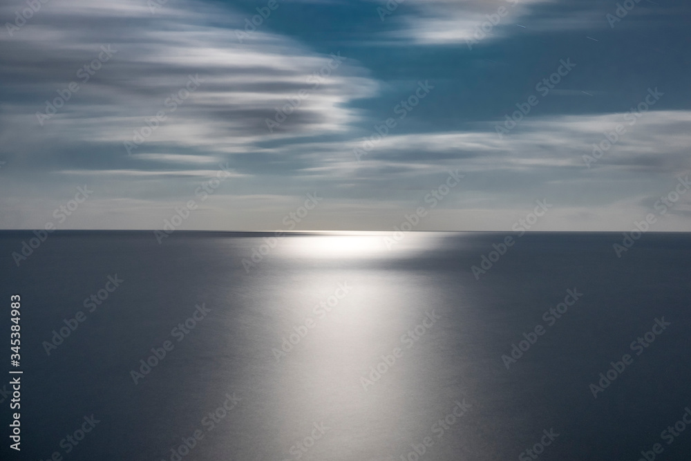 Fototapeta premium Paisaje del horizonte del mar con la luz de la luna reflejada en el agua.