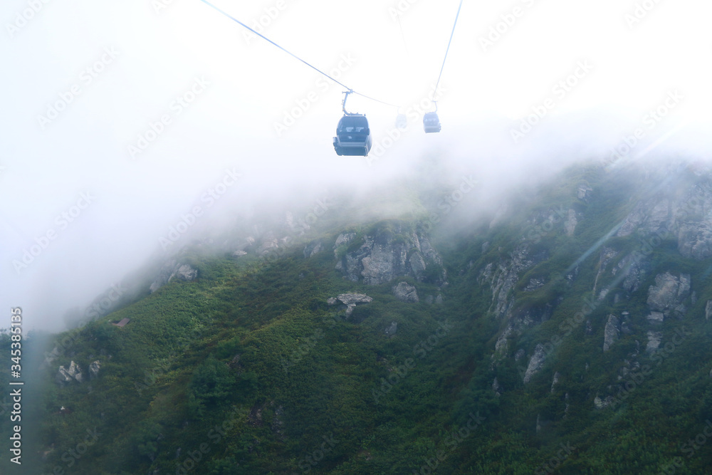 cable car in the fog with beautiful high mountains in the background