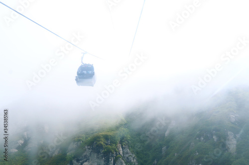 cable car in mountains with cloud or fog