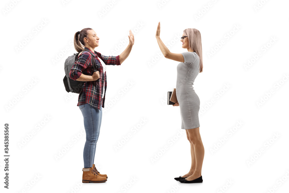 Female student gesturing high-five with a woman holding books