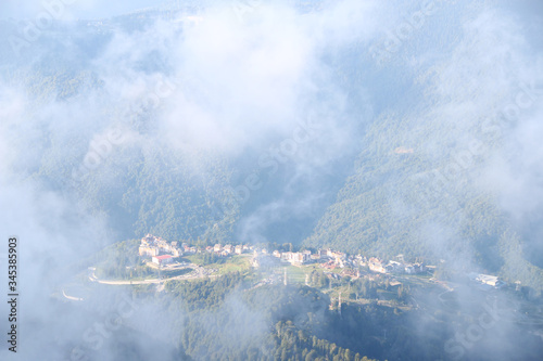view through cloud on village in mountain. Bird's eye view through clouds on mountainous city © northernrf