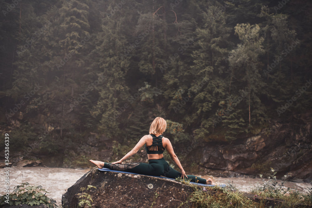 Naklejka premium The woman in the wood, meditation outdoors yoga mountain green