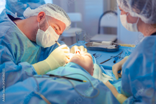 The surgeon leaned over the patient during the operation. A group of surgeons works in the operating room