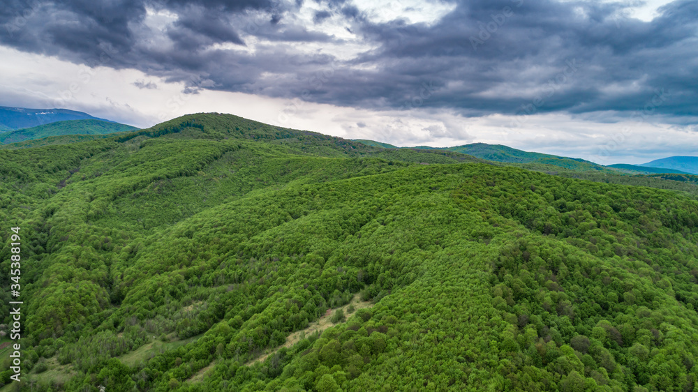 Obraz premium Spring landscape in mountains and the dark blue sky with clouds. A drone shot.