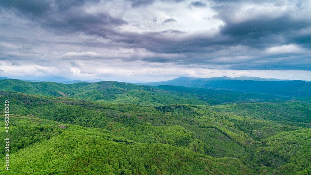 Spring landscape in mountains and the dark blue sky with clouds. A drone shot.
