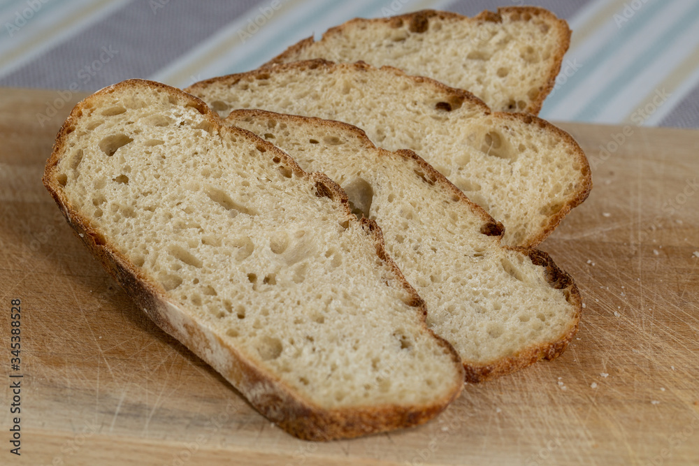 Sliced freshly baked homemade sourdough bread on a wooden board
