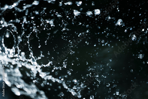 splash and drops of water on dark blue background