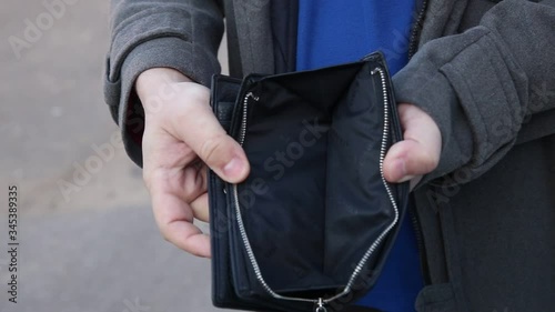 Man shows that there is no money in his wallet.