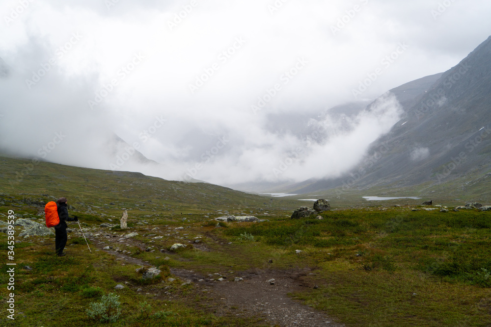 Hiker on the Kings Trail (Kungsleden) in the swedish Lapland admiring the view. 