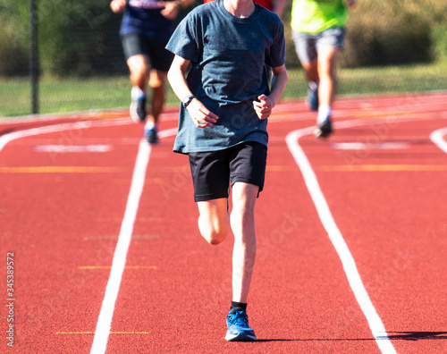 Front view of runner running in a lane on a track