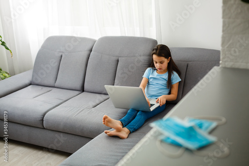 Little Girl Using Digital Laptop E-learning Concept. little girl children using laptop computer, studying through online e-learning system.