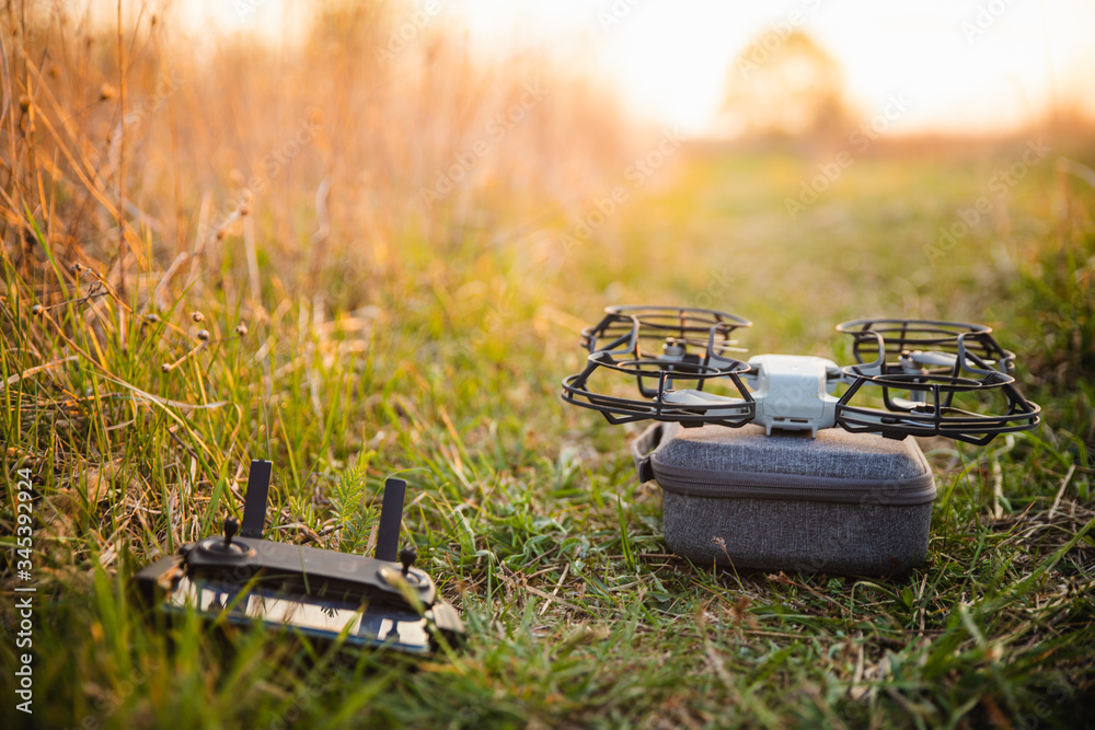 Small drone with propeller guard on green field Small drone with propeller guard on green field