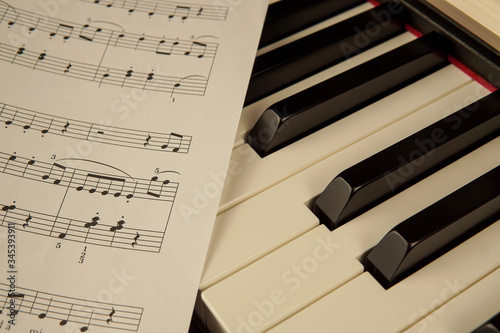 Close-up of piano keyboard with musical sheet