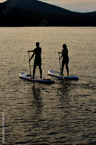 Sup boarding couple on sunset