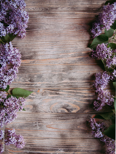 The beautiful lilac flowers on a wooden background