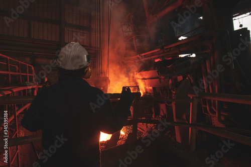 man melting steel in hot factory