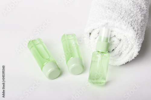 Three  bottles of hand sanitizer. Liquid soap and sanitizer for hands on greenbackground. Stay home and stay safe. Self care and antivirus security. Hand disinfection. Measures to avoid infection.