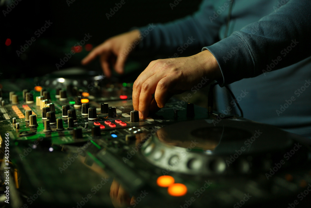 dj's hand is mixing tracks at party in night club. disc jockey playing music on the modern turntable close up dj's hand is mixing tracks at party in night club. disc jockey playing music on the modern turntable close up
