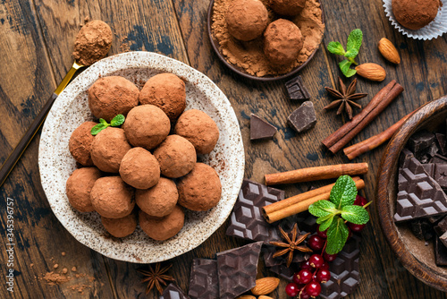 Homemade chocolate truffles with cinnamon on wooden table background, top view