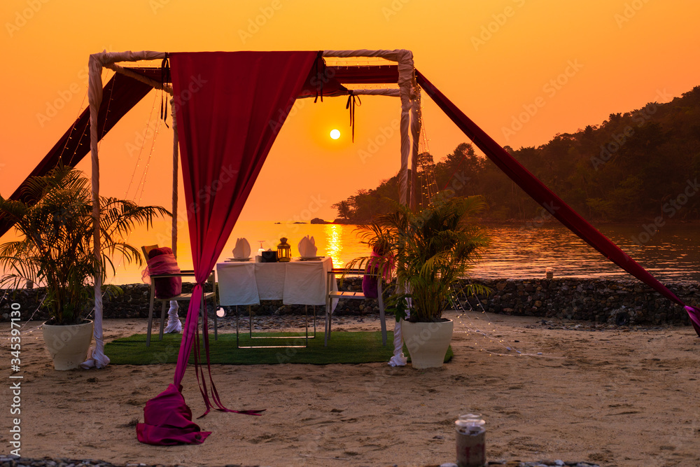 Fototapeta premium gazebo for relaxing on the beach at sunset, a romantic dinner in the privacy