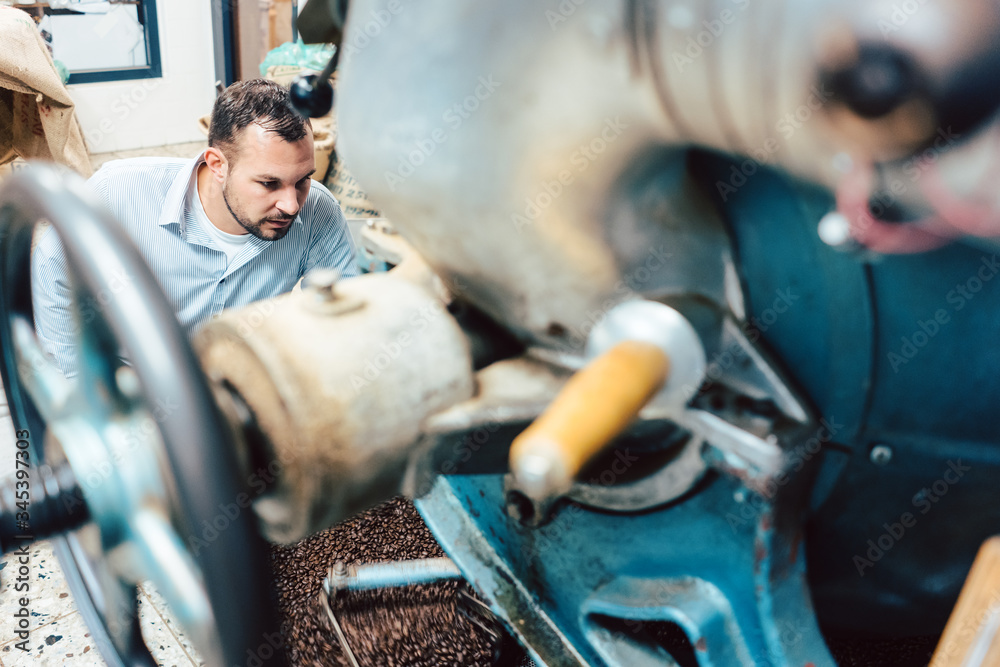 Man operating coffee roaster Man operating coffee roaster