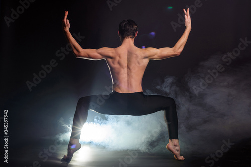 Fototapeta Naklejka Na Ścianę i Meble -  Handsome young ballet dancer on black background