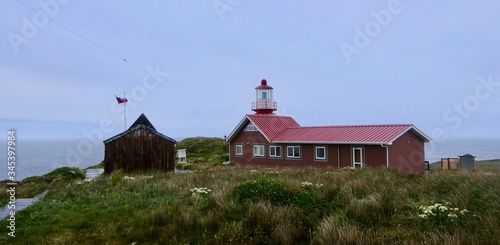 Lighthouse at cape horn in gras landscape, stormy, clouds, Chile