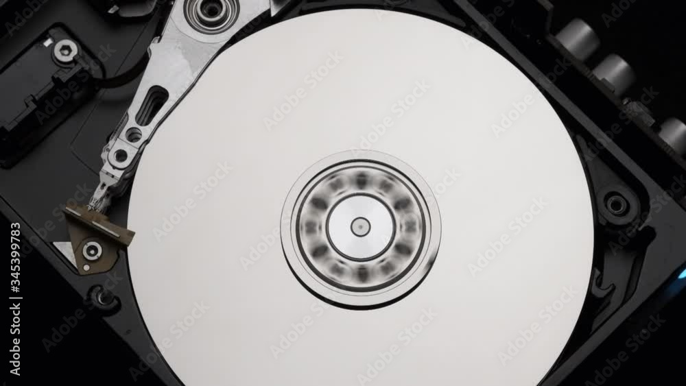 Macro, Close-Up of Computer Hard Disk Drive Spinning and Writing then Rotation Stop. Blue Lights Blinking. Slow Motion. Macro, Close-Up of Computer Hard Disk Drive Spinning and Writing then Rotation Stop. Blue Lights Blinking. Slow Motion.