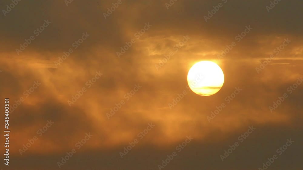 Big sun rising through the clouds, birds fly Big sun rising through the clouds, birds fly
